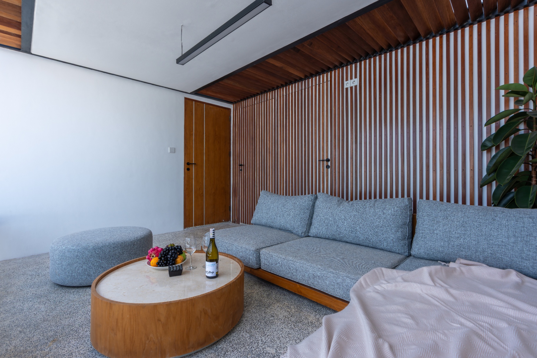 Rooftop lounge with teak-slat wall and sectional sofa